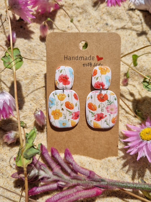 Poppy flower earrings on a white polymer clay background handmade in Australia 
